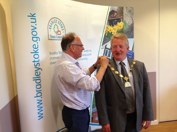 The outgoing Mayor Councillor Brian Hopkinson presents the Chains of Office to the New Mayor Councillor John Ashe.
